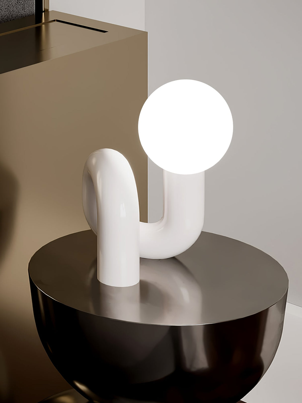 White Clérachic table lamp with a glowing globe on a black round table in a muted bedroom corner.