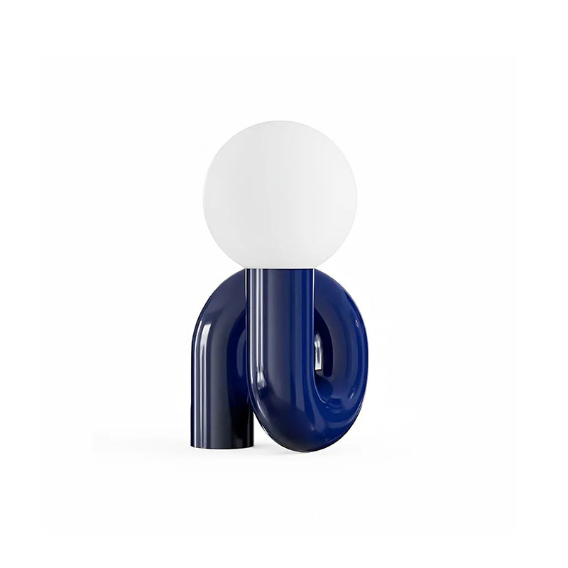 Blue Clérachic table lamp on white, the glossy tube base looping beneath a frosted white globe.