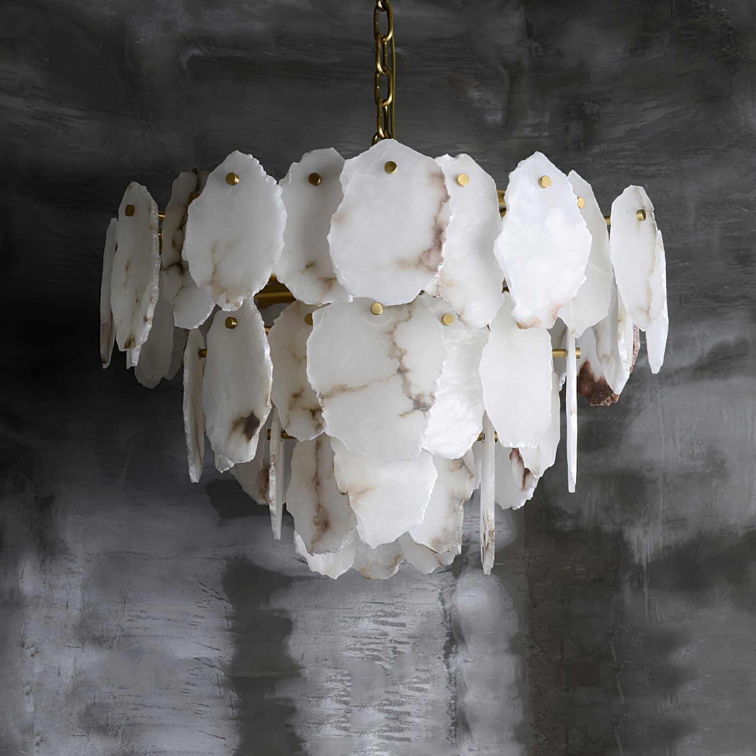 Angled view of the Clérachic Gloire chandelier where the alabaster veining runs grey and rose across the overlapping plates.