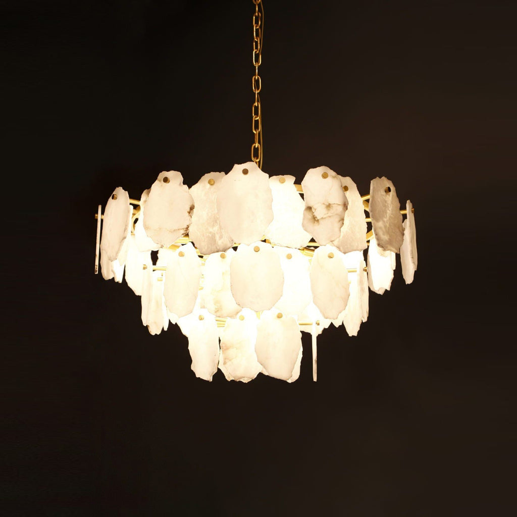 Clérachic Gloire alabaster chandelier fully lit against black, each stone plate glowing from within on its brass chain.