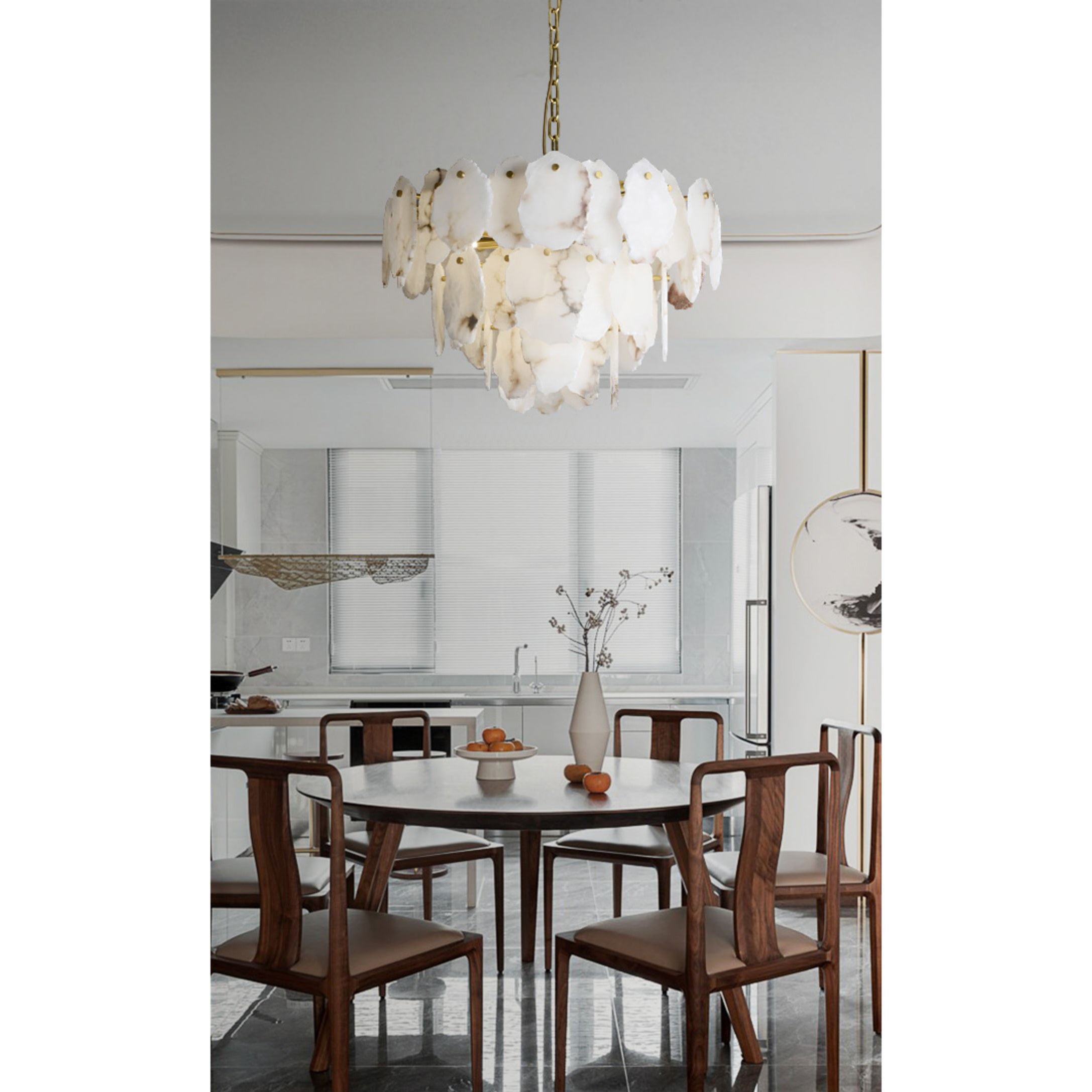 Clérachic Gloire alabaster chandelier centred above a round walnut dining table in a bright open-plan kitchen.