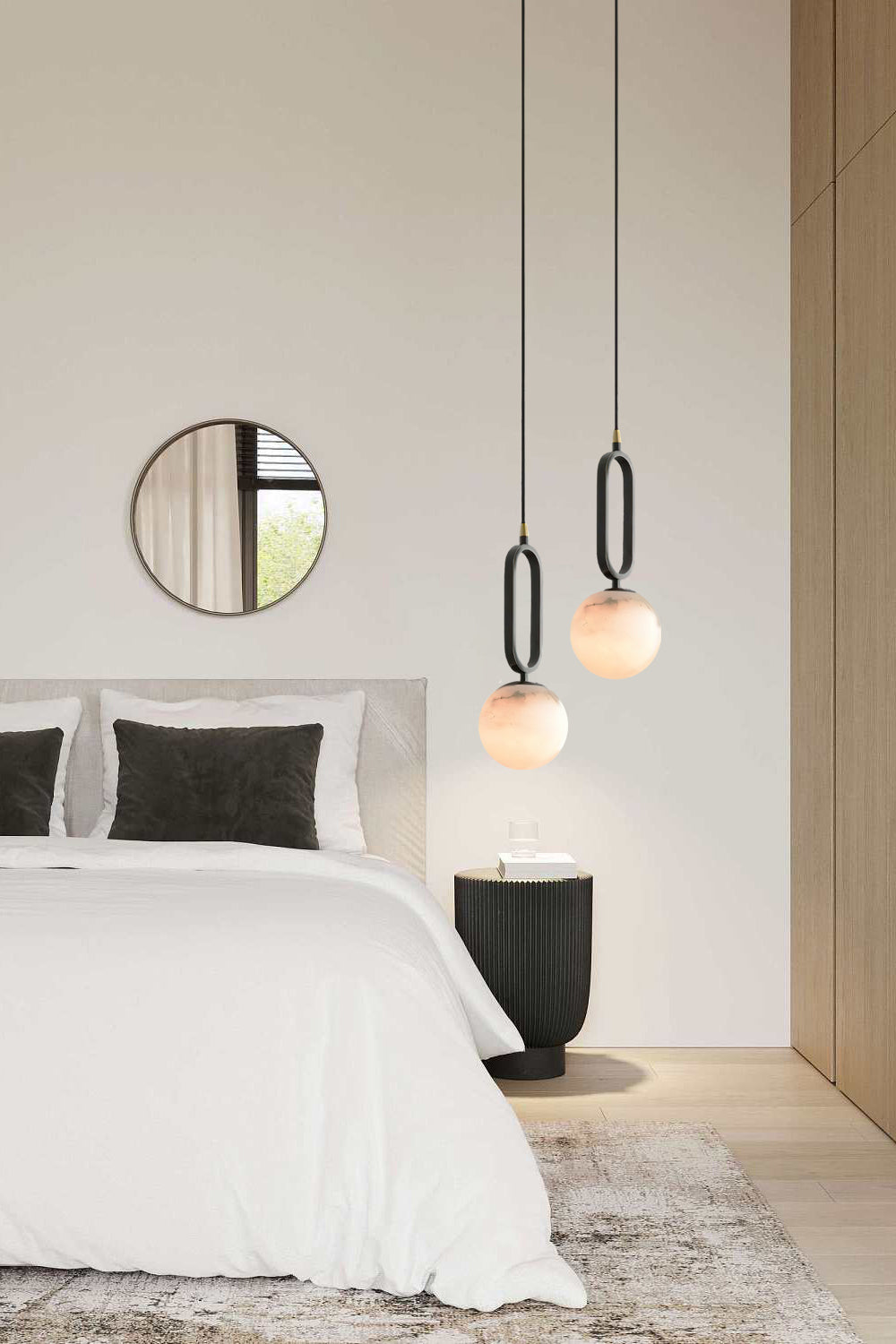 Clérachic Gloruvyd pendants stepped in a trio beside a bed, the alabaster spheres echoing a round wall mirror.