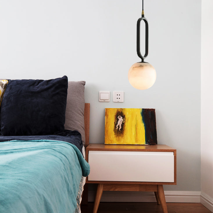 Clérachic Gloruvyd suspended over a mid-century walnut nightstand, its warm alabaster glow set against teal bedding.