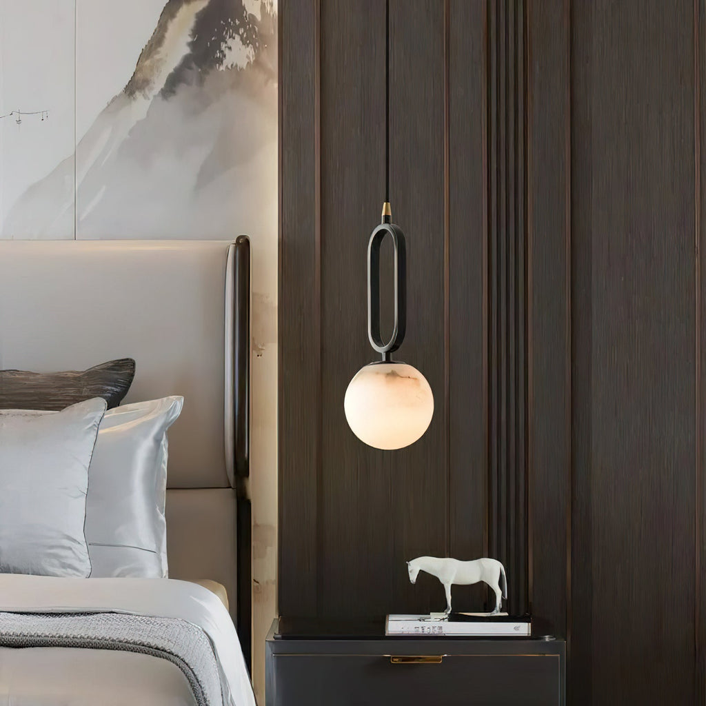The Clérachic Gloruvyd pendant against dark timber panelling, alabaster catching light above a lacquered nightstand.