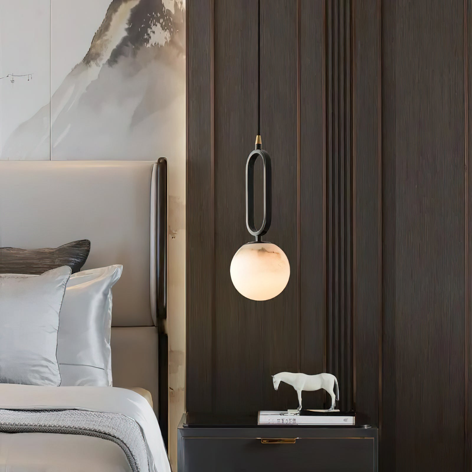 The Clérachic Gloruvyd pendant against dark timber panelling, alabaster catching light above a lacquered nightstand.