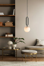 Clérachic Gloruvyd lights a reading corner, its alabaster globe glowing between built-in shelves and brass side tables.