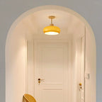 Clérachic dome ceiling light in glossy orange, mounted under an arched hallway opening above a panelled white door.