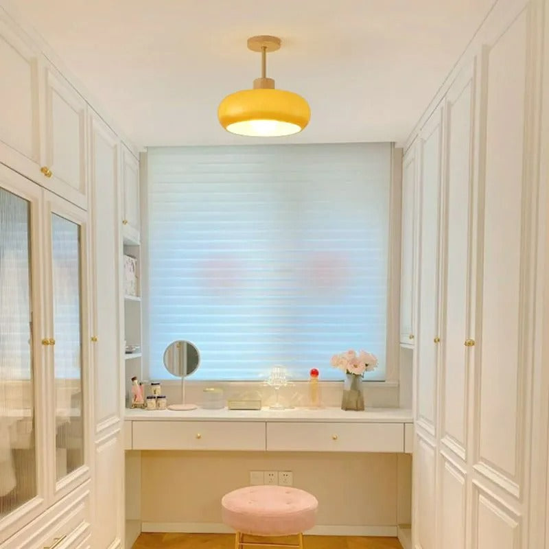 Clérachic dome ceiling light in orange, lighting a white dressing room with a mirrored vanity and pink stool.