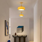 Two Clérachic orange dome ceiling lights above an entryway console table and framed artwork.