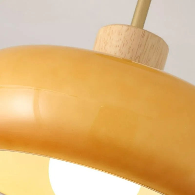 Close-up of the Clérachic dome light, the glossy orange glaze meeting the turned wood collar and brass rod.