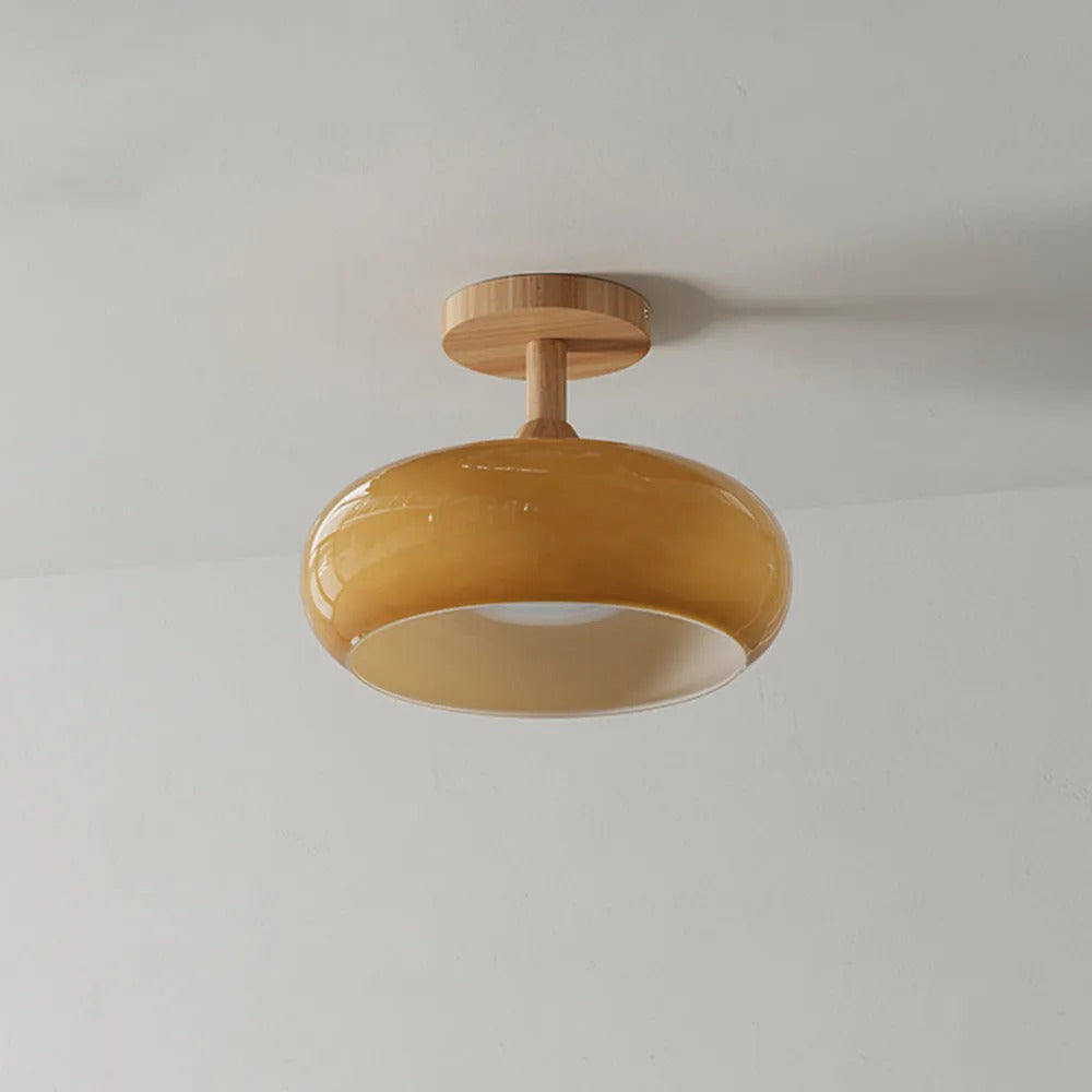 Clérachic dome ceiling light in a deeper mustard glaze, semi-flush against a plain ceiling on its pale wood plate.