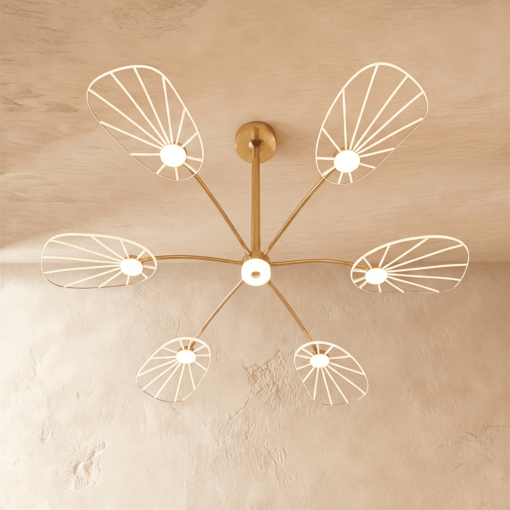 Clérachic leaf-shaped chandelier with 6 lit acrylic panels radiating from a brass stem, glowing warm on a plaster ceiling.