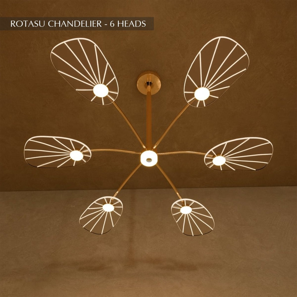Clérachic leaf-shaped chandelier, the 6-head version, its acrylic panels glowing warm against a brown plaster wall.