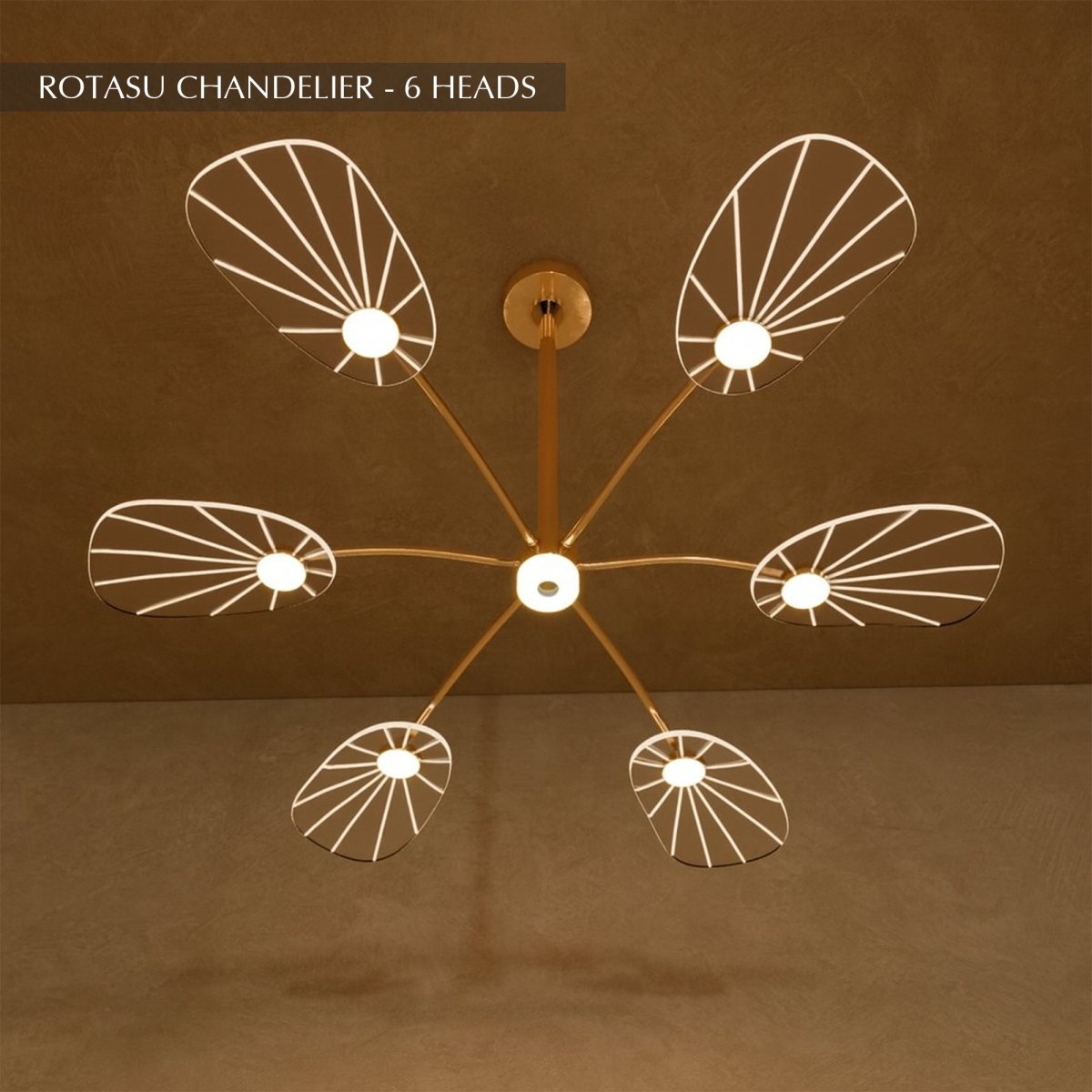 Clérachic leaf-shaped chandelier, the 6-head version, its acrylic panels glowing warm against a brown plaster wall.