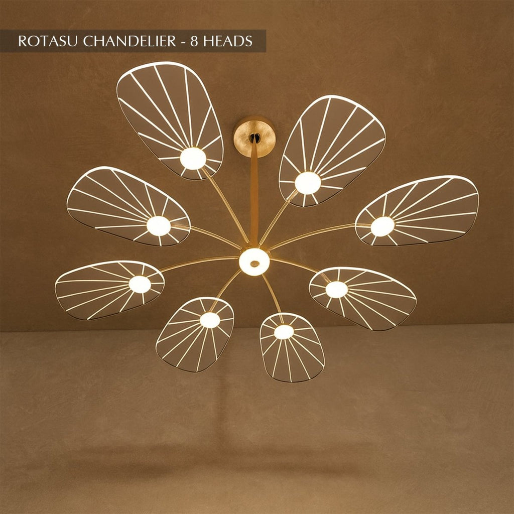 Clérachic leaf-shaped chandelier, the 8-head version, its acrylic panels glowing warm against a brown plaster wall.