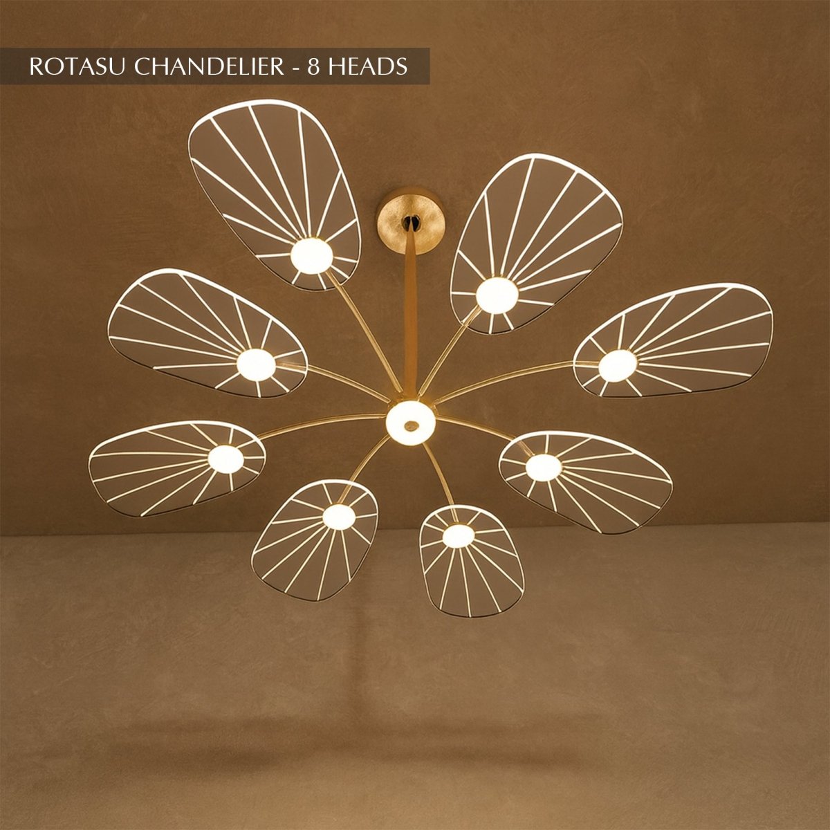 Clérachic leaf-shaped chandelier, the 8-head version, its acrylic panels glowing warm against a brown plaster wall.