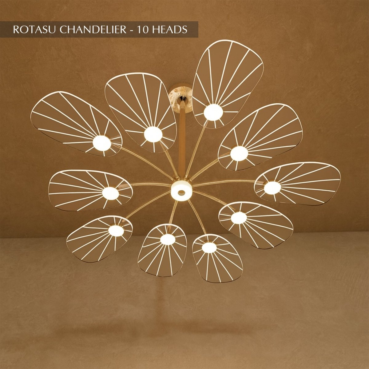 Clérachic leaf-shaped chandelier, the 10-head version, its acrylic panels glowing warm against a brown plaster wall.