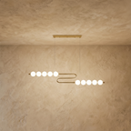 Clérachic linear chandelier with an S-shaped gold-finished rail carrying two rows of five opal spherical shades.