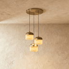 Clérachic alabaster pendant light in the 3-light cluster, glowing stone drum shades staggered at different heights.