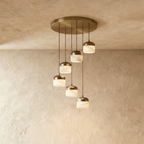 Clérachic alabaster pendant light in the 6-light cluster, viewed from another angle with all shades glowing warm.