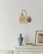 Small Clérachic wall light with a cream glass shade above a white mantel with a blue-and-white vase and a framed print.