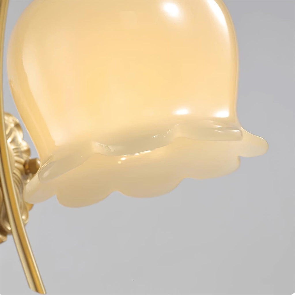 Close view of the scalloped rim and creamy glass of the flower-shaped shade on this Clérachic wall light.