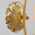 Close view of the embossed brass back plate and curved arm joint on this Clérachic wall light.