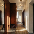 Three Clérachic faceted crystal ceiling lights running down a hallway with walnut panelling and a patterned runner.