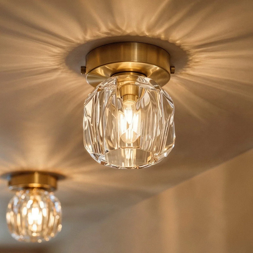 Clérachic crystal ceiling light casting a starburst of light across the ceiling, gold plate above a faceted shade.