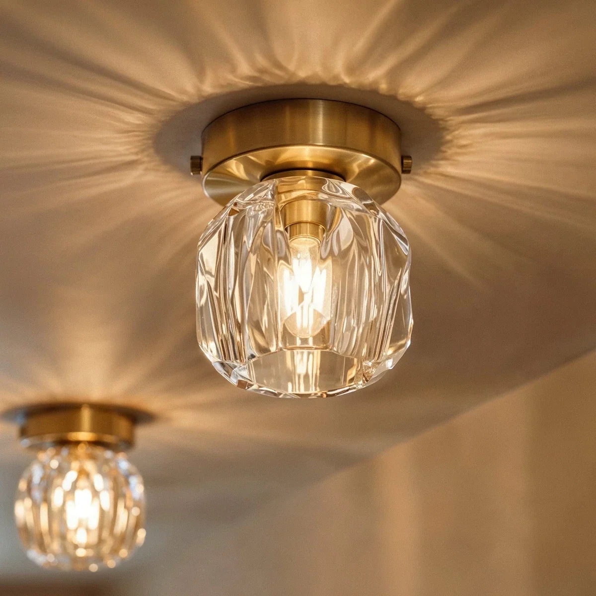 Clérachic crystal ceiling light casting a starburst of light across the ceiling, gold plate above a faceted shade.