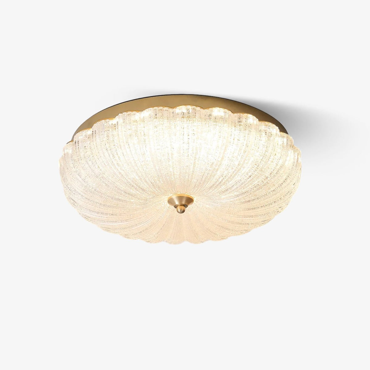Scalloped, frosted glass flush-mount ceiling light with a gold edge and a small brass finial, lit on a plain white backdrop from Clérachic.