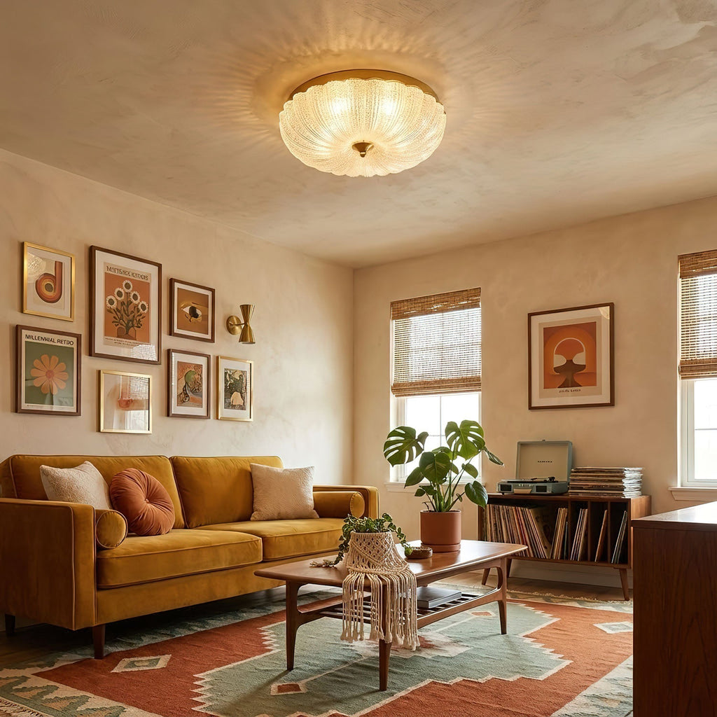 Clérachic flush ceiling light lit above a warm living room with a mustard sofa, a rust and teal rug and framed prints on the wall.