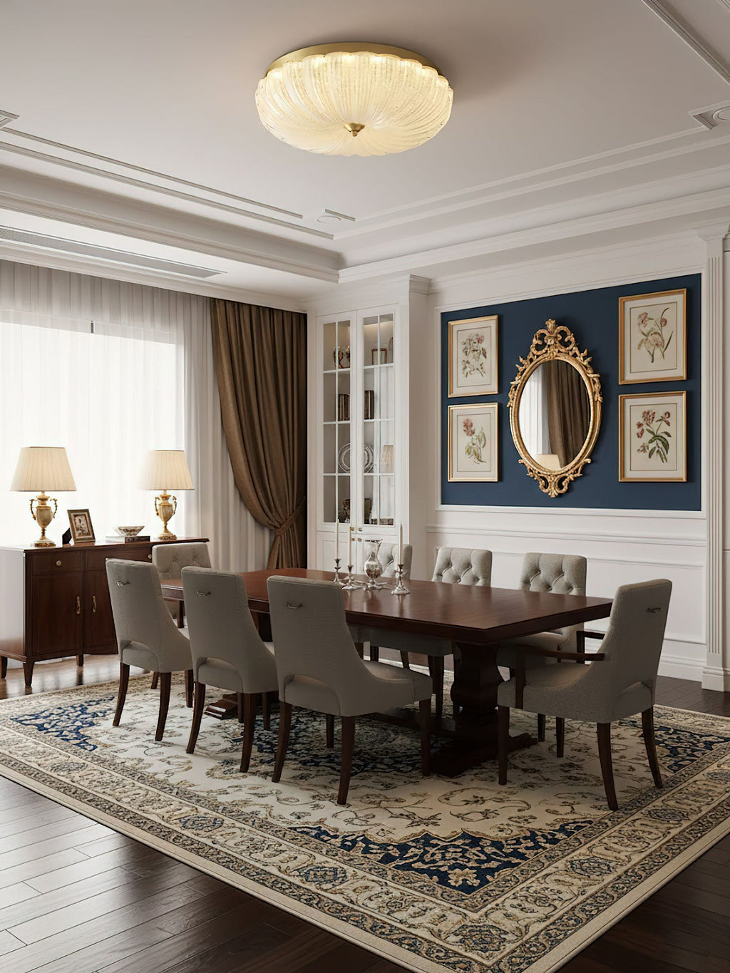 Clérachic ceiling light lit above a dark wood dining table with grey chairs, a navy wall with a gold mirror and table lamps beyond.
