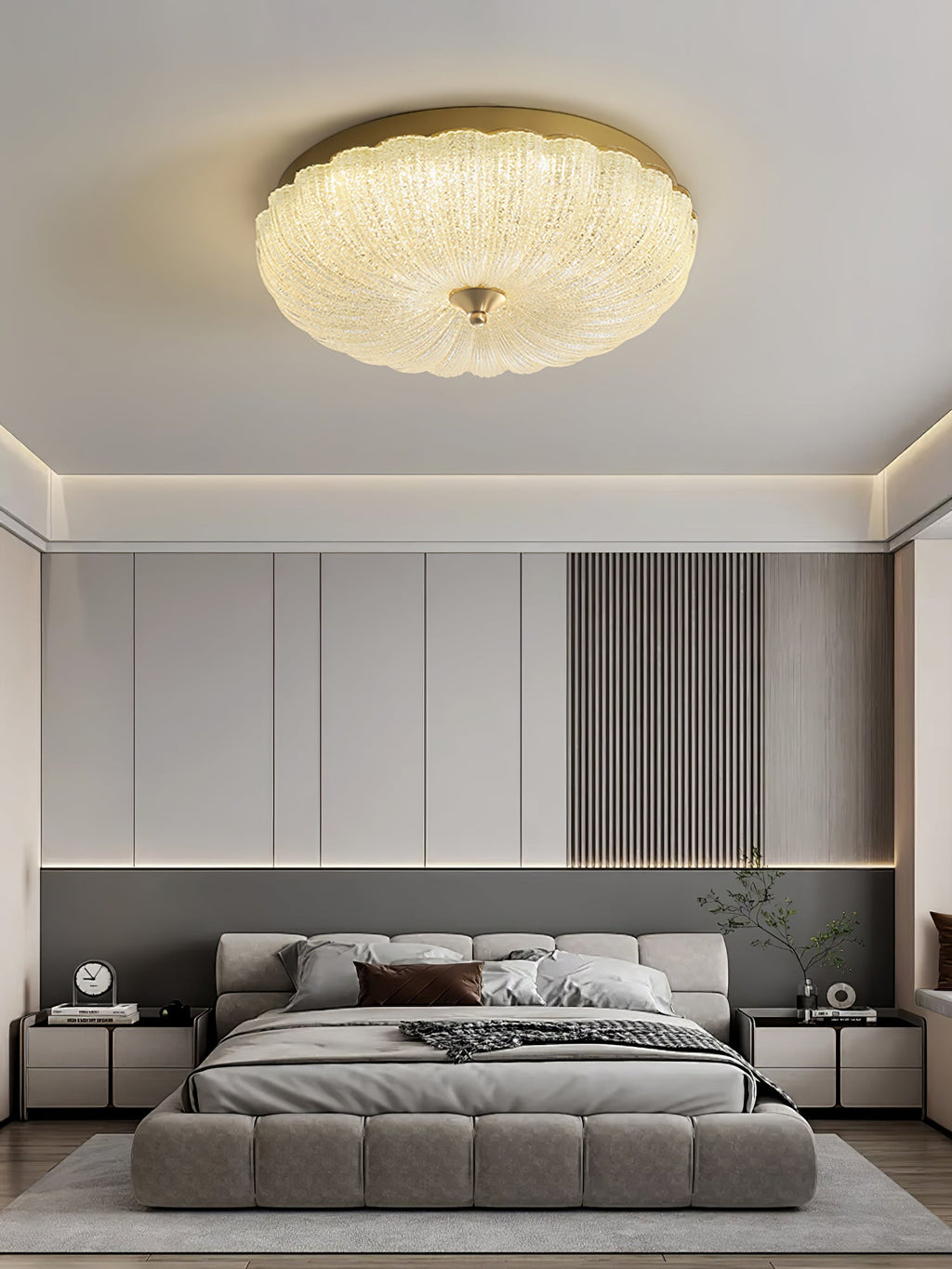 Clérachic flush ceiling light above a bedroom with a low grey upholstered bed, a slatted panel and a pale rug.