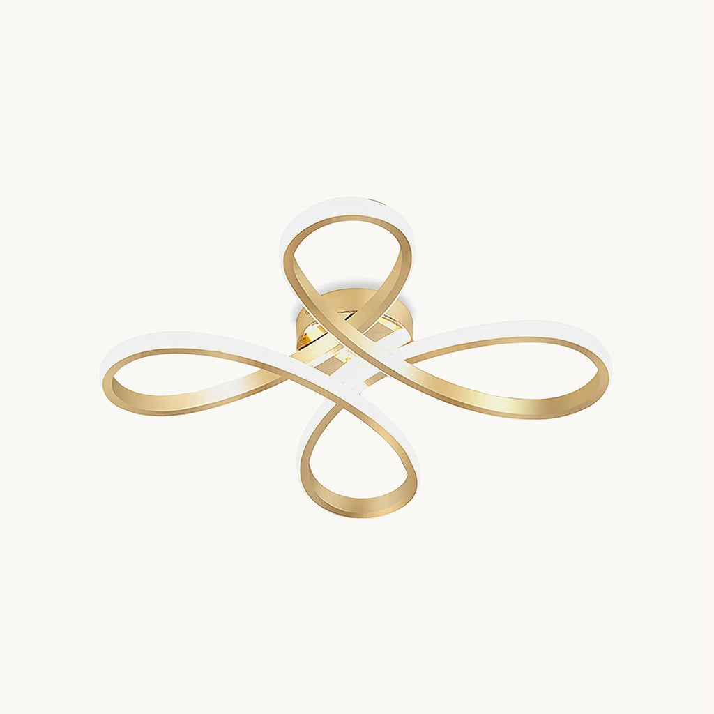 This Clérachic ceiling light on a plain white backdrop, a gold ribbon folded into four looping petals with a white diffuser along the inner edge.