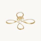 This Clérachic ceiling light on a plain white backdrop, a gold ribbon folded into four looping petals with a white diffuser along the inner edge.