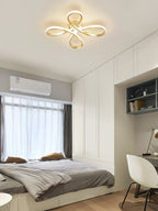Gold Clérachic ceiling light over a small bedroom with a built-in white wardrobe, a grey bed and a white chair at the desk.