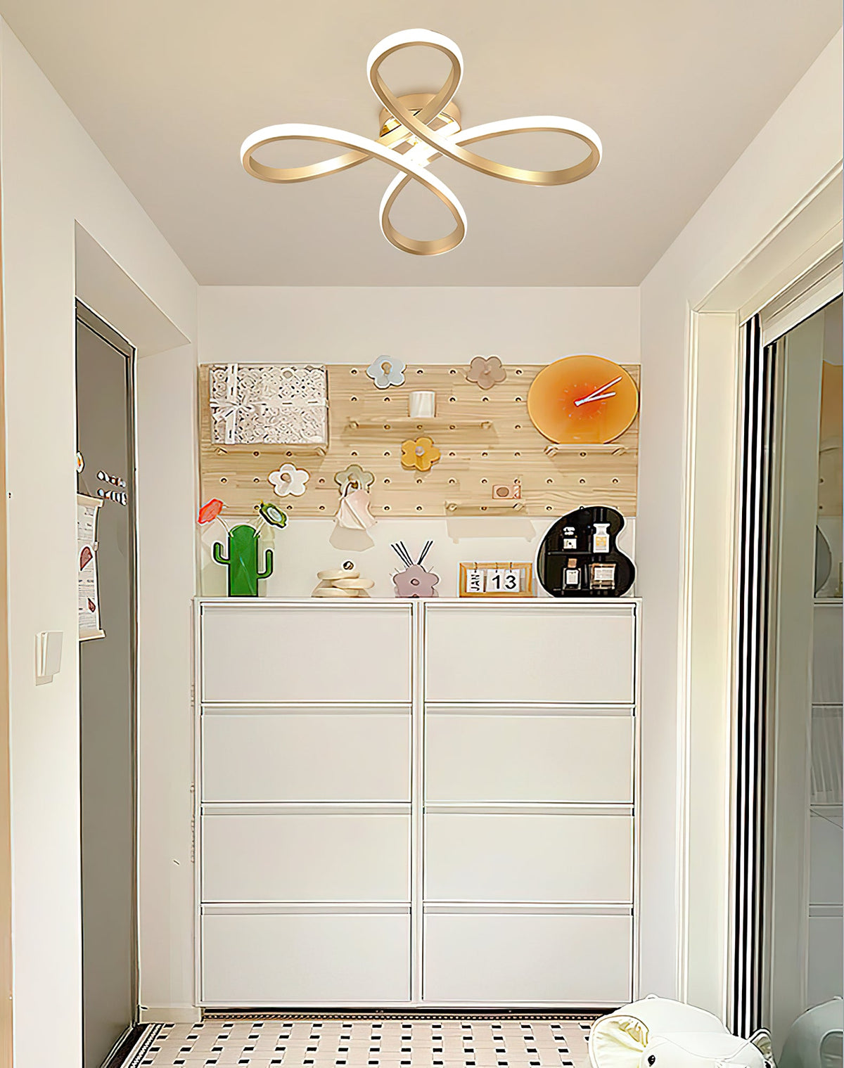 A Clérachic ceiling light in a narrow entrance room, above white drawers and a pegboard wall hung with small objects.