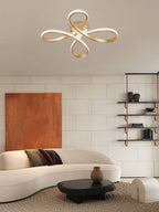 Clérachic ceiling light above a curved cream sofa, a low black table and a terracotta-toned artwork on a white tiled wall.