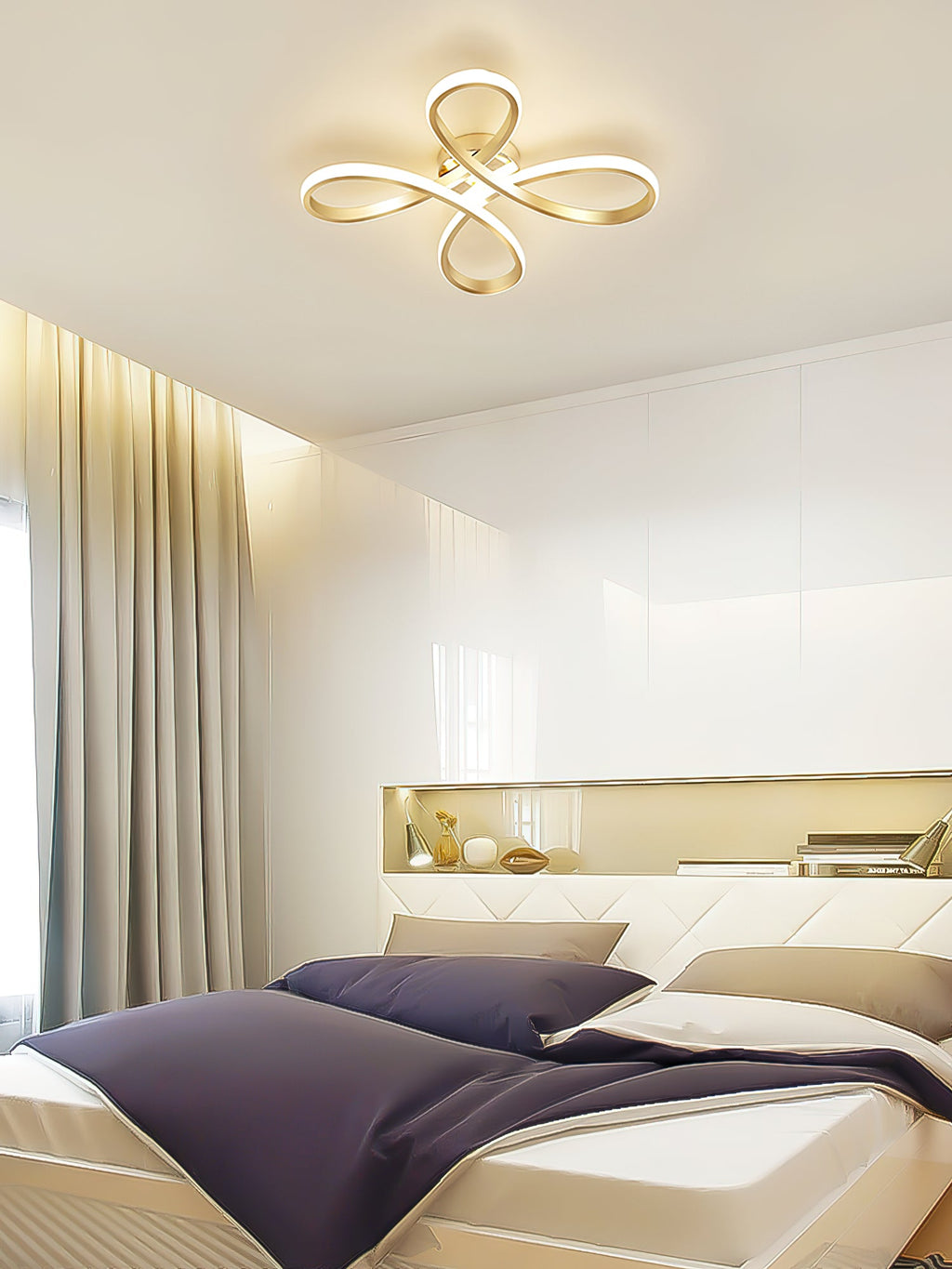 Clérachic ceiling light lit above a bed with navy bedding and a quilted white headboard, with a lit shelf niche behind.