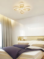 Clérachic ceiling light lit above a bed with navy bedding and a quilted white headboard, with a lit shelf niche behind.