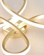 Very close view of the loops and round gold base of this Clérachic ceiling light, lit and glowing warm on the ceiling.