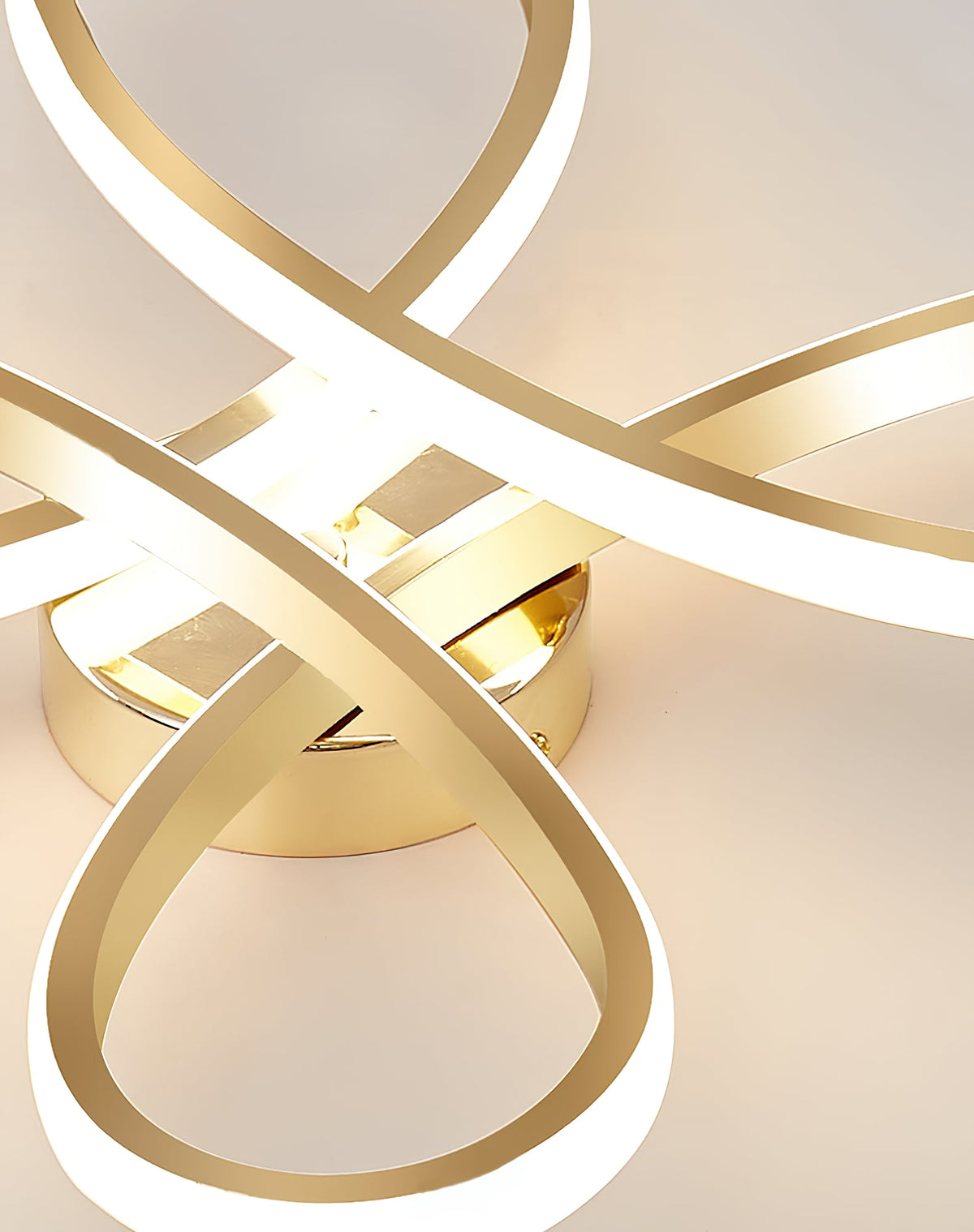 Very close view of the loops and round gold base of this Clérachic ceiling light, lit and glowing warm on the ceiling.