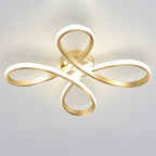 Clérachic gold ceiling light from below, its four loops lit, seen against a pale grey-blue ceiling.
