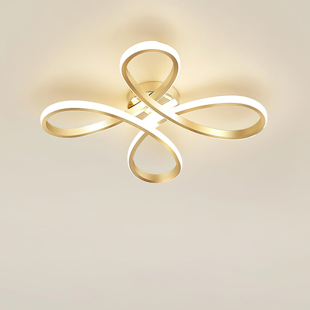 Clérachic gold ceiling light lit against a cream ceiling, the white diffuser strip glowing along each loop.