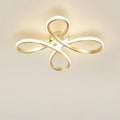 Clérachic gold ceiling light lit against a cream ceiling, the white diffuser strip glowing along each loop.