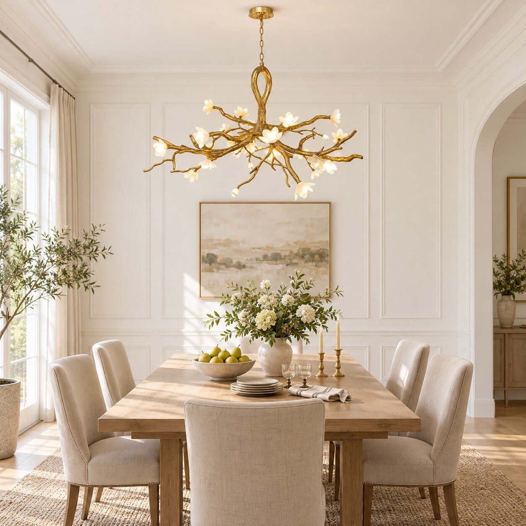 Centred on a panelled white wall, this Clérachic chandelier hangs above a long pale-wood table set with pears and candlesticks.