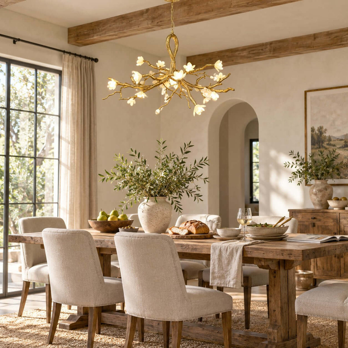 Warm light from the Clérachic chandelier falls across a rustic dining table, under exposed ceiling beams and an arched opening.