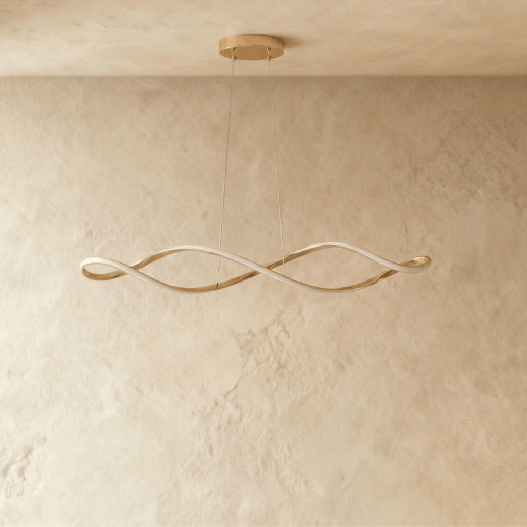 A studio view of the Clérachic chandelier's gold twisted ribbon form, lit and hung on slim cables from the ceiling.