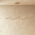 A studio view of the Clérachic chandelier's gold twisted ribbon form, lit and hung on slim cables from the ceiling.